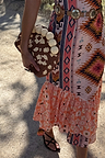 Jaden Beaded Clutch Bag with brown and white beadwork and cream spheres, held against a colourful print dress.