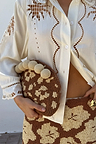 Jaden Beaded Clutch Bag with brown and cream beadwork and sphere trim, held with a matching beaded skirt.