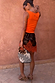 Tan Jaden Floral Mini Maeva Skirt with orange lace trim, styled with an orange tank and beaded bag.