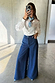 Blue Denim Pallazzo Jan Jean with a wide-leg fit, paired with a white shirt and a blue patterned neck scarf.
