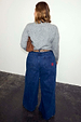 Blue Denim Pallazzo Jan Jean with a wide leg and red pocket embroidery, shown from behind for inclusive sizing.