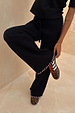 Black Night Garden Knit Jogger featuring pink blanket stitch detailing and wide legs, styled with leopard print trainers.