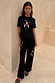 Black Night Garden Knit Joggers with colourful embroidered motifs and pink patterned trim on a model.