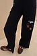 Thumbnail for Night Garden Knit Joggers in black with colourful embroidery and pink whipstitch detailing on the side and hem.