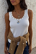 Deloris Key Necklace featuring an iconic key motif and red gemstone, layered on a polished brass chain over a white top.
