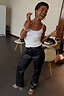 Thumbnail for Black Vegan Leather Studded Leg Trousers with silver side studs, styled with a white tank top.