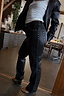 Thumbnail for Black vegan leather trousers with silver studs along the side and pocket, styled for a London look.