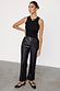 High-waisted black vegan leather trousers with a straight leg, styled with a black ribbed tank top.