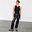 Black Vegan Leather Trousers in a straight-leg, high-waisted fit, styled with a black tank top and flats.