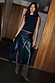 Black Vegan Leather Wrap Skirt with a tulip shaped tie, styled with a black top and knee-high boots.