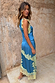 Blue satin Millie Skirt with lemon lace detailing and an asymmetric hem, styled as a co-ord against a rustic wall.