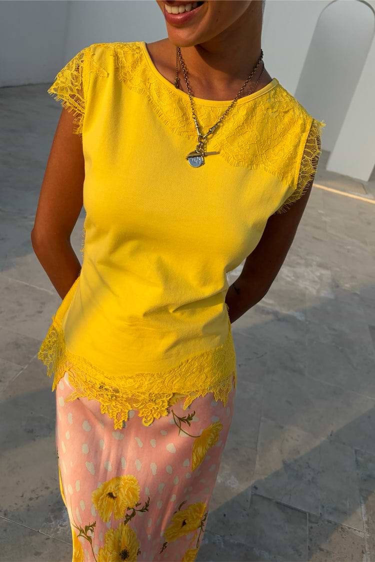 Yellow Lace Insert Top featuring cap lace sleeves and an asymmetric hem, paired with a floral skirt.