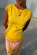 Yellow Lace Insert Top featuring cap lace sleeves and an asymmetric hem, paired with a floral skirt.