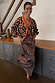Iconic leopard print cardigan featuring cherry details and red contrast trims, styled with a matching maxi skirt.