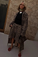 Lucia Leopard Denim 55 Coat Petite in leopard print, styled with matching shorts and red floral sandals against a stone wall.