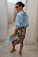 Iconic Brown Leopard Jaspre Skirt in a satin wrap style, paired with a light blue shirt and colourful clutch.