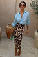 Brown Leopard Jaspre Skirt in a sleek satin wrap style, paired with a light blue shirt and sunglasses.