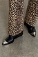Wide leg Leopard Lucia Scallop Detail Jeans styled with black pointed-toe boots with silver hardware.