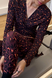 Dark Leopard Leggings and matching wrap top with contrast orange detailing, shown in a gym setting.