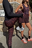 Thumbnail for Dark Leopard Leggings in a burgundy animal print with orange accents, styled for activewear on a London street.