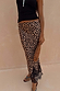 Leopard print Midi Maeva Skirt with a black lace border, styled with a black top and matching patterned clutch.