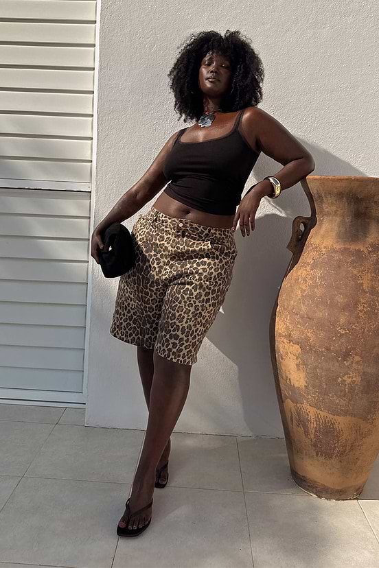 Leopard Lucia Scallop Pocket Long Shorts in denim, styled with a black tank top next to a large terracotta urn.