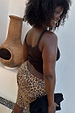 Leopard Lucia Scallop Pocket Long Shorts in brown animal print denim, styled with a brown vest and black clutch.