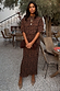 Lucia Leopard Tilly Dress Petite in iconic leopard print plisse, featuring an elasticated waist in an outdoor café.