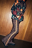 Iconic leopard print ski trousers with a bright orange side stripe and flared hem, styled with a patterned jacket.