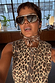 Iconic Leopard Waistcoat in cotton with engraved buttons, styled with a brown patterned neck scarf and oversized sunglasses.