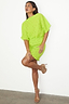 Lime Plisse Mini Tilly Dress with gold dots, a dopamine dressing staple for a vacation capsule wardrobe.