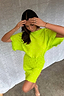 Model wearing the Lime Plisse Mini Tilly Dress with gold foil spots and textured flared sleeves.