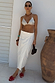 White Linen Jaspre wrap skirt with multi-wear ties, styled with a sequin top for a vacation look.