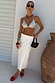 White Linen Jaspre Skirt in a wrap style, paired with a silver sequin top and red sandals.