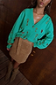 Thumbnail for Turquoise Key Cardigan featuring a gold lock and key print, paired with a tan suede mini skirt.