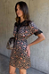 Iconic Cherry Leopard Mini Lyla Dress with black lace trims and tie neck, styled with a matching leopard print bag.