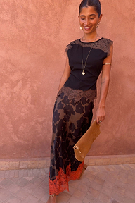 Tan Jaden Floral Maeva Skirt with an orange lace hem, styled with a black top and tan clutch bag.