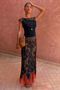 Tan Jaden Floral Maeva Skirt with an orange lace hem, styled with a black lace top for a vacation evening look.