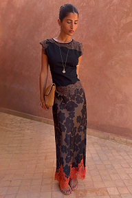 Tan Jaden Floral Maeva Skirt with an orange lace hem, styled with a black lace-detail top and clutch.