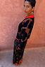 Modella con Gonna Maeva in stampa floreale Jaden marrone, orlo in pizzo arancione e maglia coordinata.