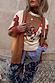 Cowgirl Martha Cardigan in tan with vintage western embroidery and red stitching, layered over a striped shirt.