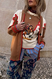 Cowgirl Martha Cardigan in tan with vintage western embroidery and red stitching, layered over a striped shirt.