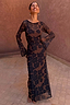 Thumbnail for Tan Jaden Floral Mesh Maxi Dress with flared sleeves and a high neckline, worn against a terracotta background.