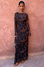 Thumbnail for Tan Jaden Floral Mesh Maxi Dress with sheer sleeves and high neck on a model against a pink textured wall.