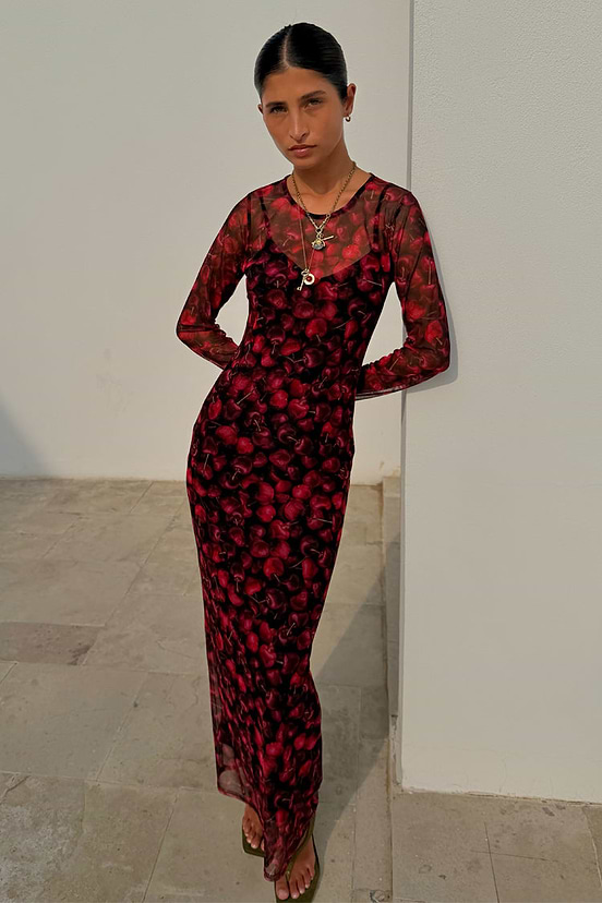 Cherry Mesh Soho Dress with a red digital cherry print, sheer long sleeves and a maxi length, worn by a model.