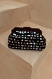 Black Beaded Mirror Bag featuring silver geometric glass beading and a wooden handle on a stone step.