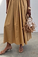 Camel Monika Dress with a pleated skirt, styled with a beaded fringe bag and tan kitten heel sandals.