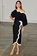 Black Mono Scallop Jaspre Skirt with white scallop trim and wrap tie, styled with a matching one-shoulder top.