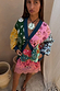 Morocco Martha Knit Cardigan in a multi-coloured sun and eye print with blue hems, styled with a lace mini skirt.