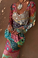 Pastel Morocco Mesh Vivi Dress featuring sun and eye motifs, styled with a beaded clutch and sun necklace.